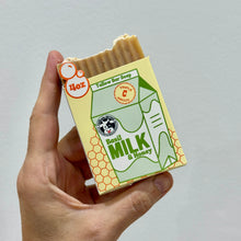 Load image into Gallery viewer, Hand holding a bar of Basil Milk & Honey Tallow soap with a packaging design resembling a milk carton.